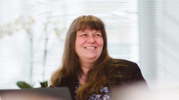Helena Wilkinson sitting at desk smiling