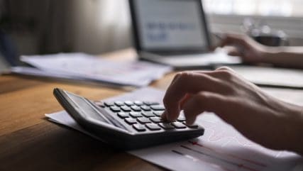 close up of hand using a calculator