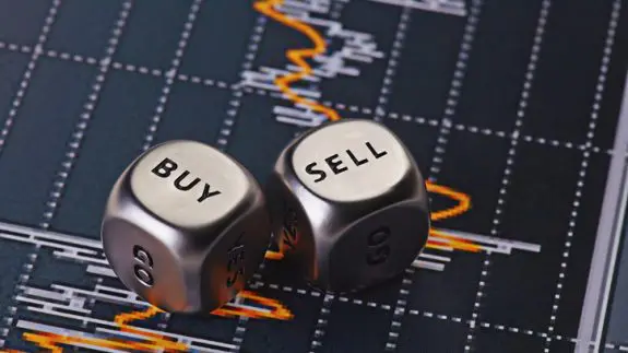two silver dice on a map with buy and sell