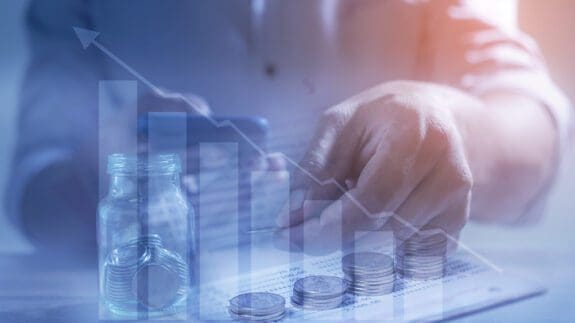 close up of hand counting money with graphic chart overlay