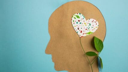 Paper-cut head with a colourful flower on top.