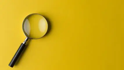 Magnifying glass on yellow background
