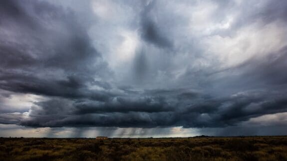 empty field at dusk with storm clouds