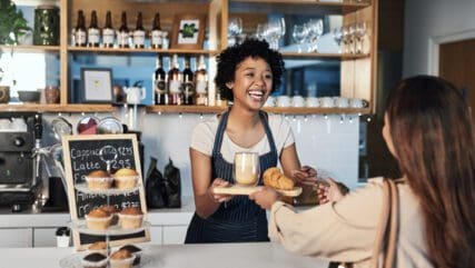 Young woman paying tip to a server