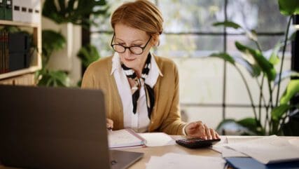 Mature businesswoman calculating finances in an home office
