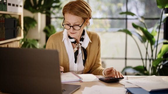 Mature businesswoman calculating finances in an home office