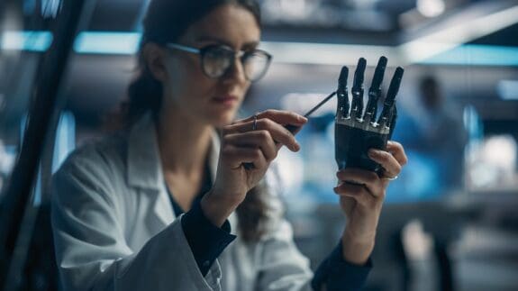 Young Female Scientist Working in Technological Research and Development Company, Assembling an Innovative Bionic Prosthetic Hand.