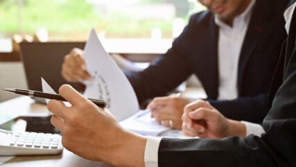 Two people reviewing information on a document