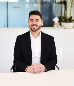 Lee Sharman sitting at desk smiling