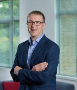 William Wilson standing in office smiling