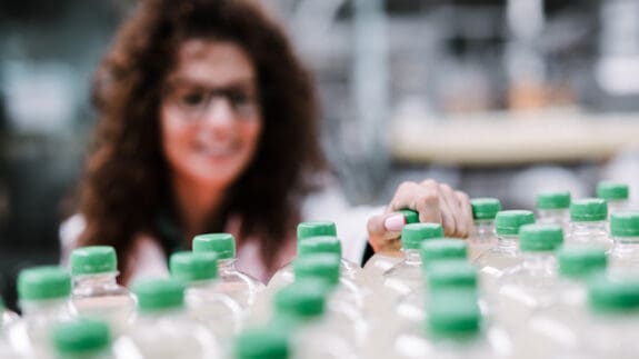 green plastic bottles in front woman looking in background