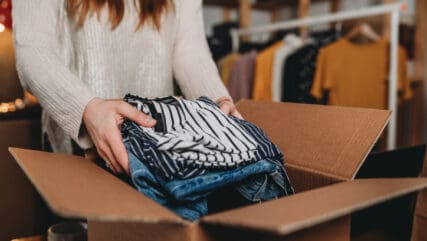 A woman is preparing the shipment of some clothes in her new online shop