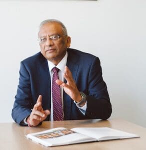 Jay Sanghrajka sitting at desk talking