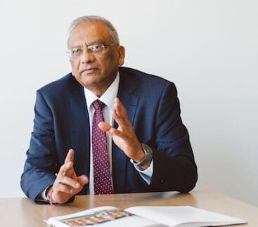 Jay Sanghrajka sitting at desk talking