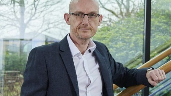 Stephen Reed standing in office smiling