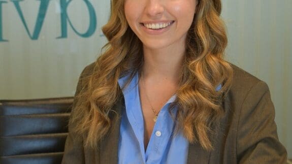 Eleanor Lodge Staff headshot sitting at desk smiling