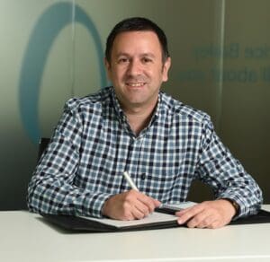James Elvin sitting at desk smiling at Price Bailey Office, Norwich