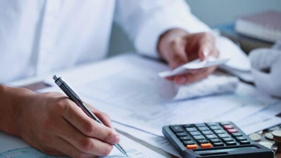 Man hand filling tax form. Close up.