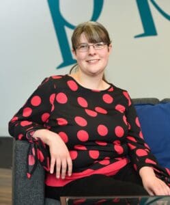 Charlotte Anson sitting in Price Bailey Cambridge office smiling