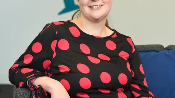 Charlotte Anson sitting in Price Bailey Cambridge office smiling