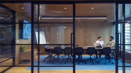 Business people working in a board room with a laptop and digital tablet. Manager working with an employee, job interview, sales, lawyer or a financial advisor.