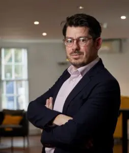 Tom Meeks standing in office smiling with arms folded