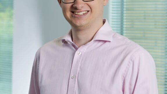 Ian standing in office smiling