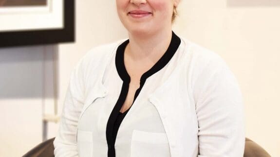 India sitting in office smiling