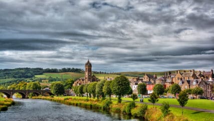 green village by the river on cloudy day