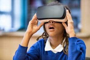 A young student wearing a school uniform using a VR headset.