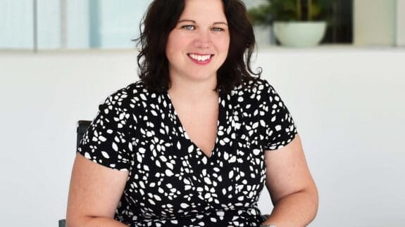 Claire Berry sitting at desk smiling