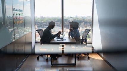 Two professionals in a modern office discussing financial details, highlighting the importance of accurate BPR valuations