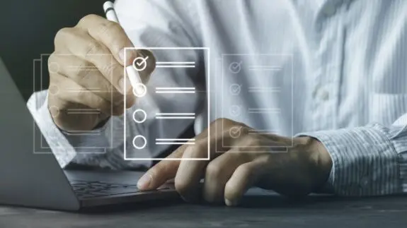 man at desk with icon overview of checkboxes