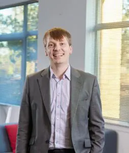 Photo of Louis Hobart stood in the Price Bailey Cambridge office.