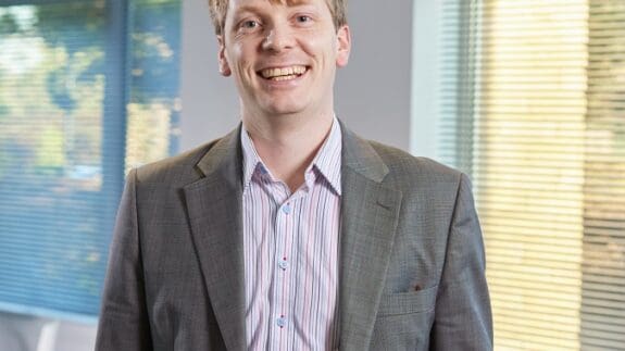 Photo of Louis Hobart stood in the Price Bailey Cambridge office.