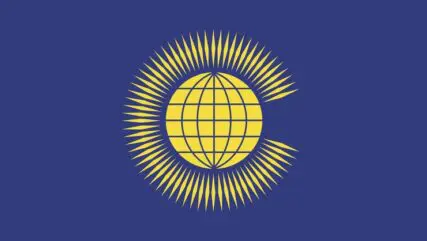 The flag of the Commonwealth - a dark blue background with a yellow globe in the centre surrounded by thin yellow diamonds.
