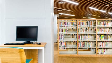 Computer and bookshelves in modern library
