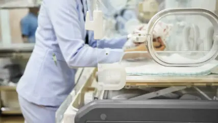 Cropped shot of pediatrician nurse keeping a newborn baby inside incubator at NICU