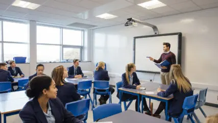 Male teacher is teaching a group of teenagers in a high school lesson.