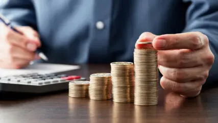 Person adding coins to stacks
