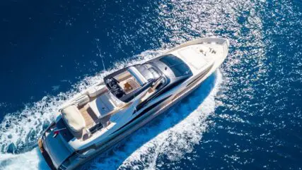 An aerial shot of a yacht sailing on the sea at daytime