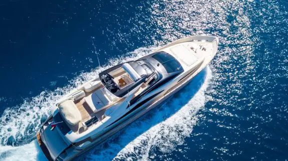 An aerial shot of a yacht sailing on the sea at daytime