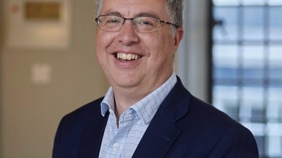 Simon Blake headshot, smiling in Mayfair office