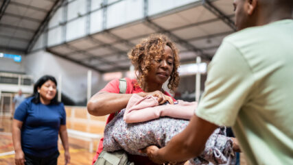 Senior woman receiving a blanket from a soldier at a community center