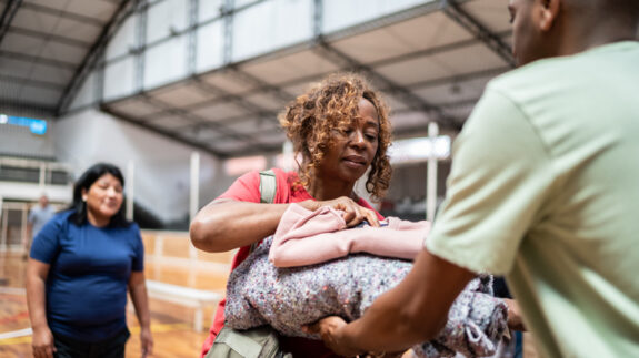 Senior woman receiving a blanket from a soldier at a community center